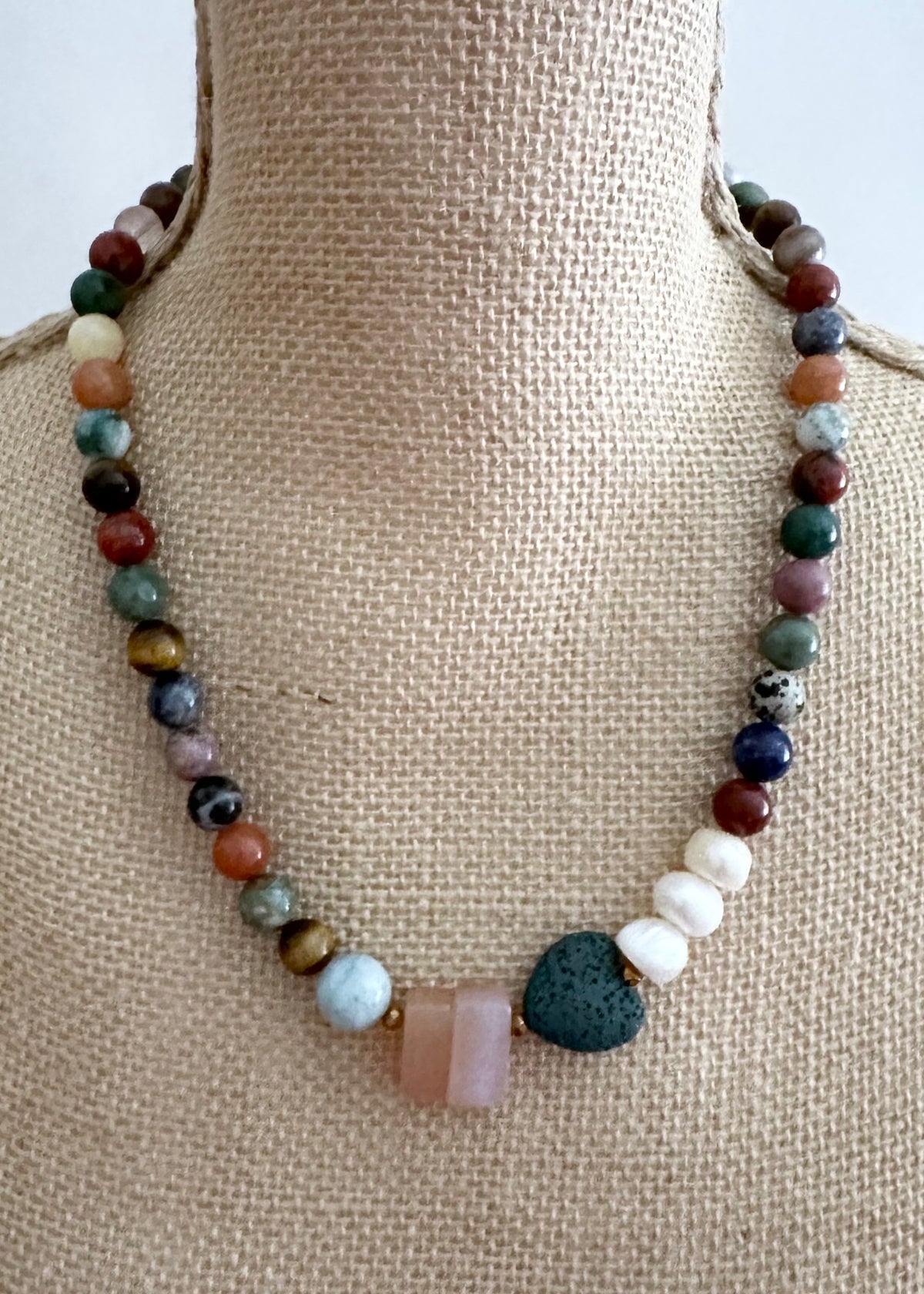 Designed and Made in Canada, this 22” Limited-Edition Necklace features a mix of round semi-precious stones in pretty Fall Shades highlighted by Aquamarine, Pink Chalcedony, a green Lava Stone Heart and 3 Lustrous Pearls finished with a Magnetic Clasp.