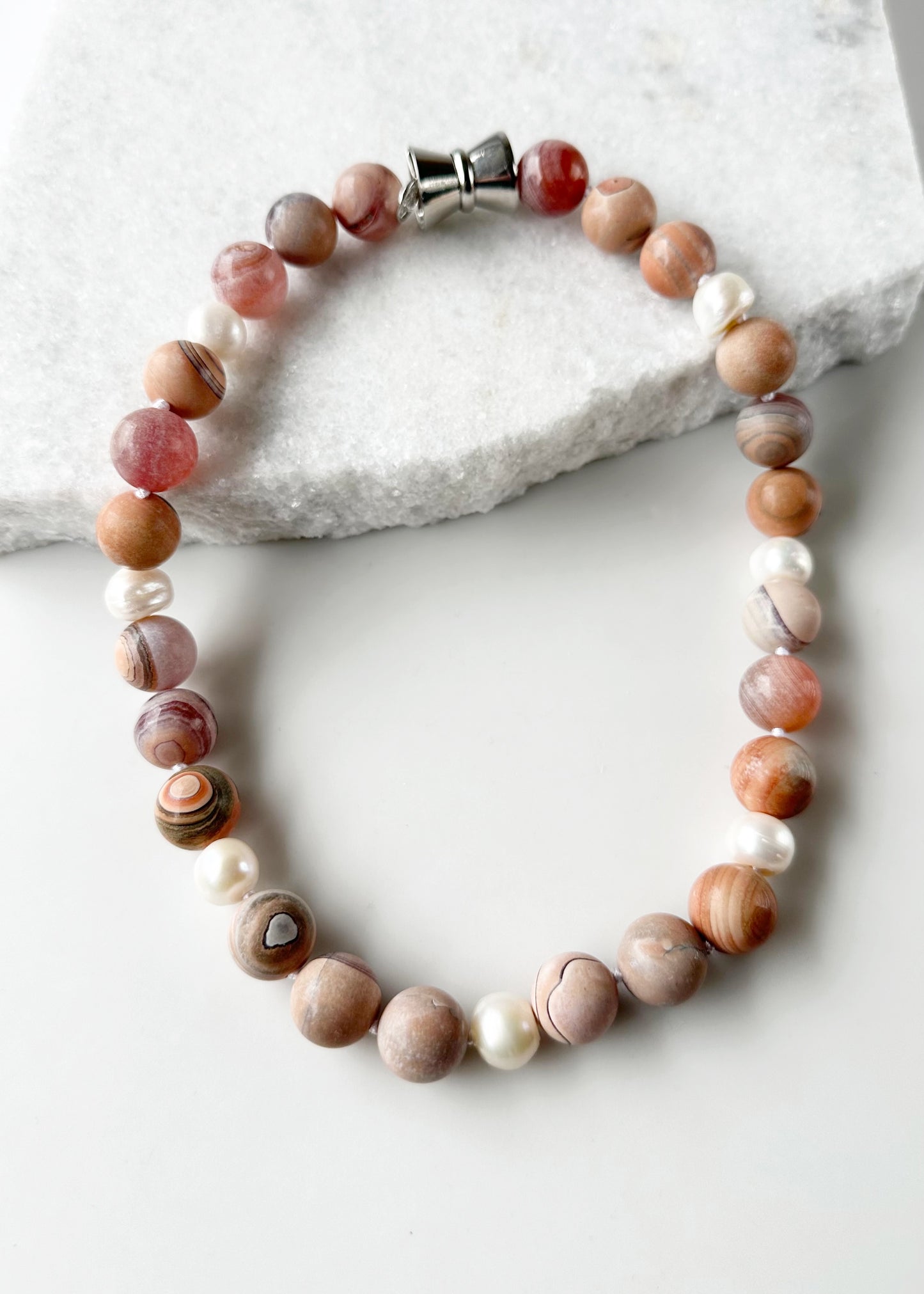 This 19.5” Necklace Highlights Large (16mm) Round Agate with Shades of Peach, Grey and Mauve with White Pearls. It fastens Effortlessly with a Convenient Magnetic Clasp, combining style and ease. Designed in Canada