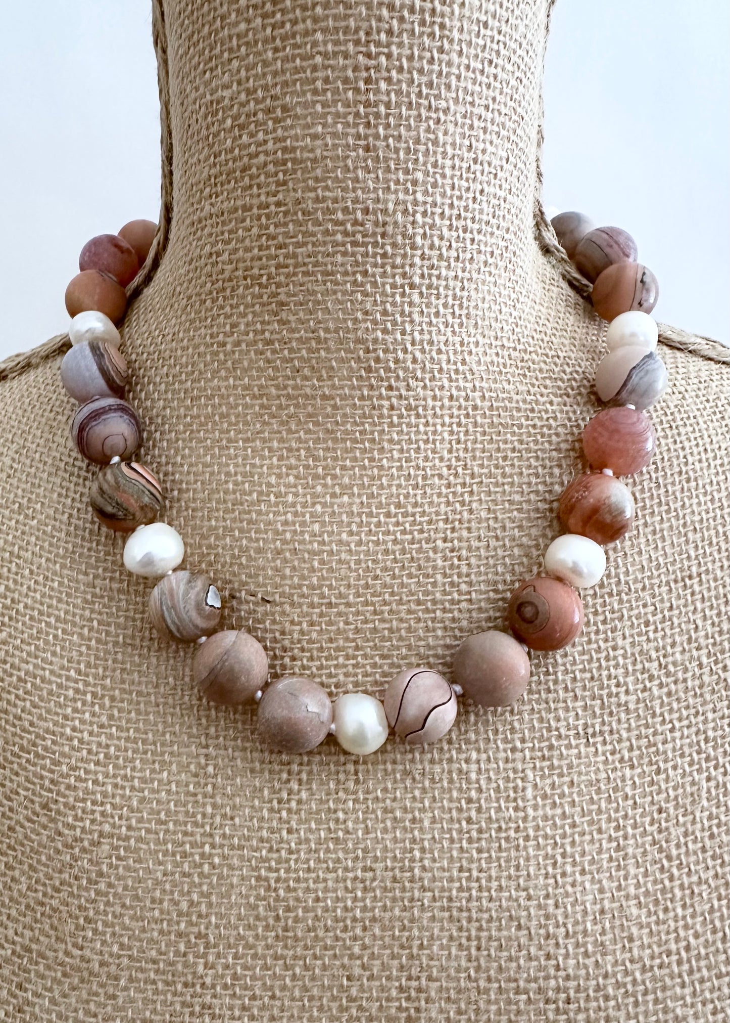 This 19.5” Necklace Highlights Large (16mm) Round Agate with Shades of Peach, Grey and Mauve with White Pearls. It fastens Effortlessly with a Convenient Magnetic Clasp, combining style and ease. Designed in Canada