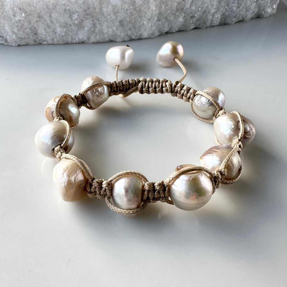 
                      
                        Nine Large Champagne Baroque Freshwater Pearls on Beige Knotted Cord Plus Sliding Knot Closure with Two Smaller Pearls to Offer Adjustable Length.
                      
                    