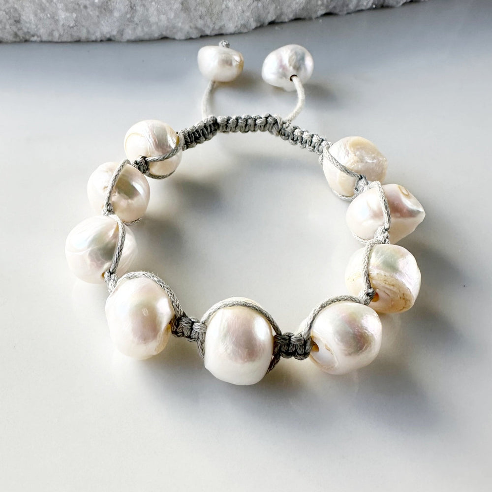 
                      
                        Nine Large White Baroque Freshwater Pearls on Grey Knotted Cord Plus Sliding Knot Closure with Two Smaller Pearls to Offer Adjustable Length.
                      
                    