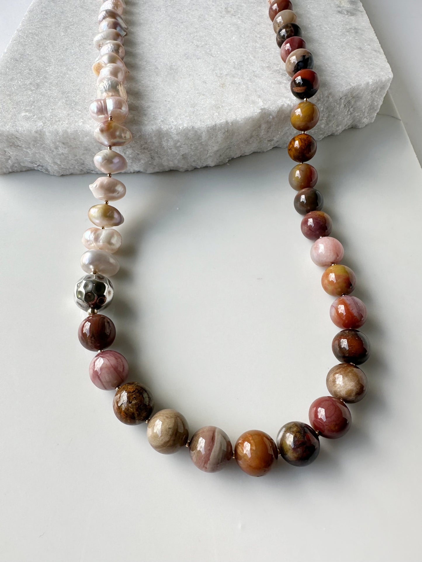 This Stunning, One-Of-A-Kind Piece has Large Baroque Soft Pink Freshwater Pearls with 14mm Petrified Wood in Brown Gold Rust and Pink for a 34” Necklace that is Completed by a Lobster Claw Clasp and Accented by Silver and Gold-Filled Beads. Focus on Petrified Wood Colors and Finish