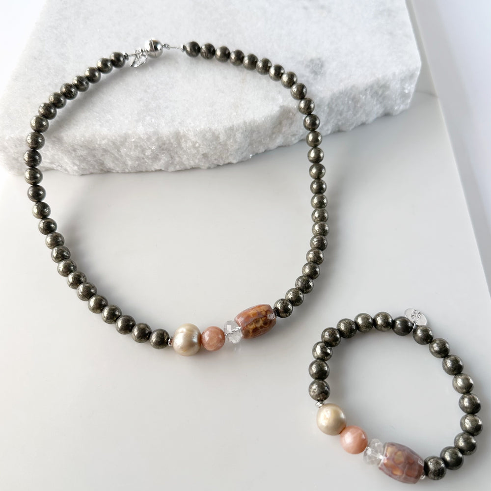 
                      
                        This 18.5” Limited Edition Necklace Boasts 8mm Pyrite, Gold Freshwater Pearl, Peach Moonstone, Clear Quartz, Brown-Scale Faceted Agate and Hematite. With Matching Pippa Bracelet
                      
                    