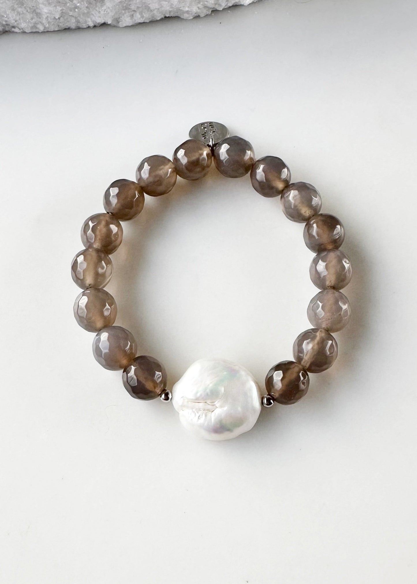 Freshwater White Coin Pearl Is Combined with 10mm Grey Agate and Glass with Metal Accents to form this Stretch Bracelet. A Subtle Yet Sophisticated Statement.