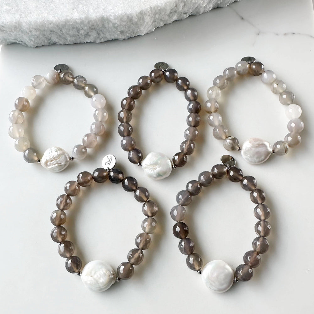 
                      
                        Freshwater White Coin Pearl Is Combined with 10mm Agate and Glass with Metal Accents to form this Stretch Bracelet. A Subtle Yet Sophisticated Statement.
                      
                    