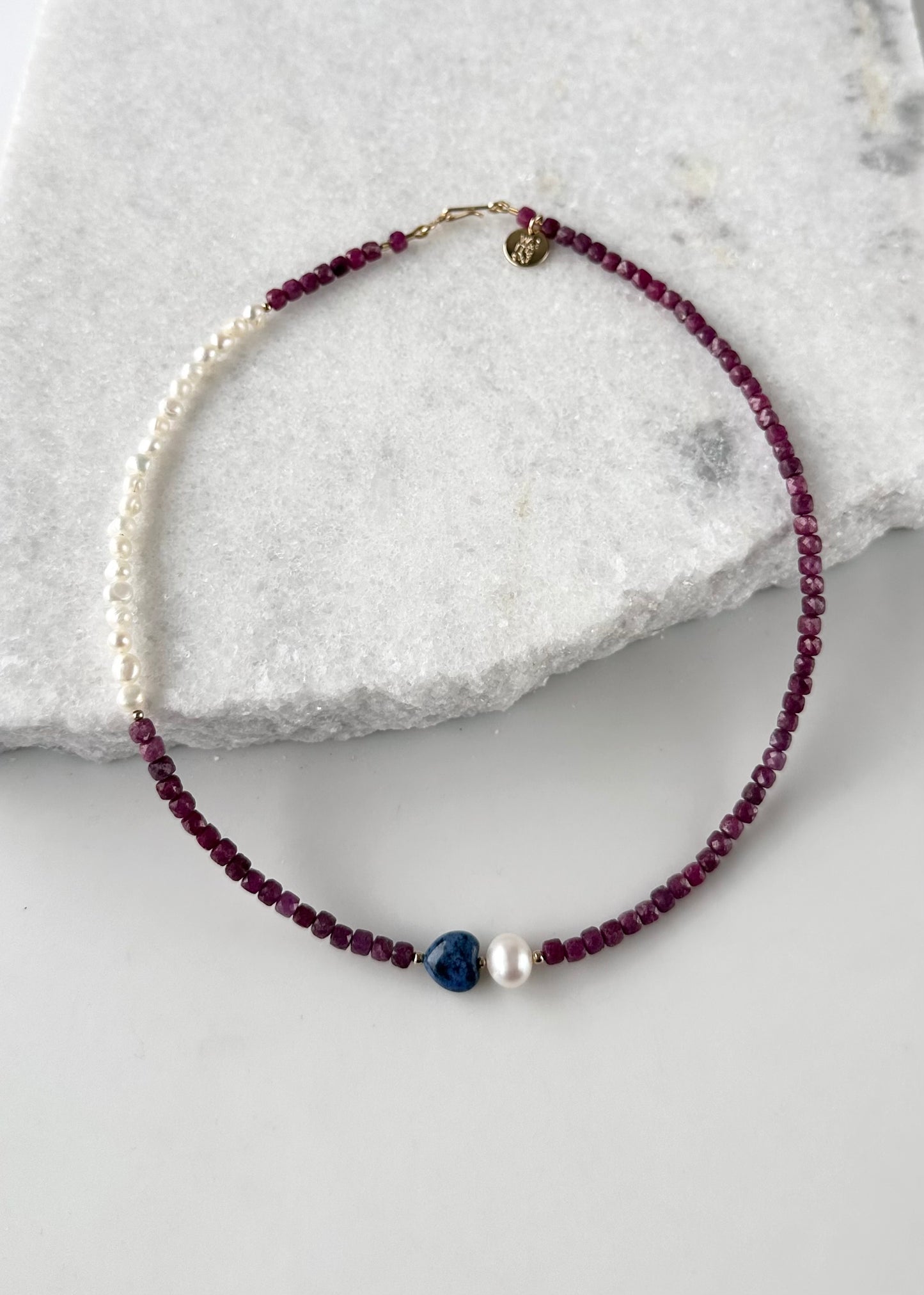 Designed and made in Canada, this Delicate One-Of-A-Kind 18” Necklace features Gorgeous Faceted 4mm Ruby, a Blue 10mm Dumortierite Heart and White Pearls accented with Gold Beads and finished with a Gold-Filled Hook Clasp.