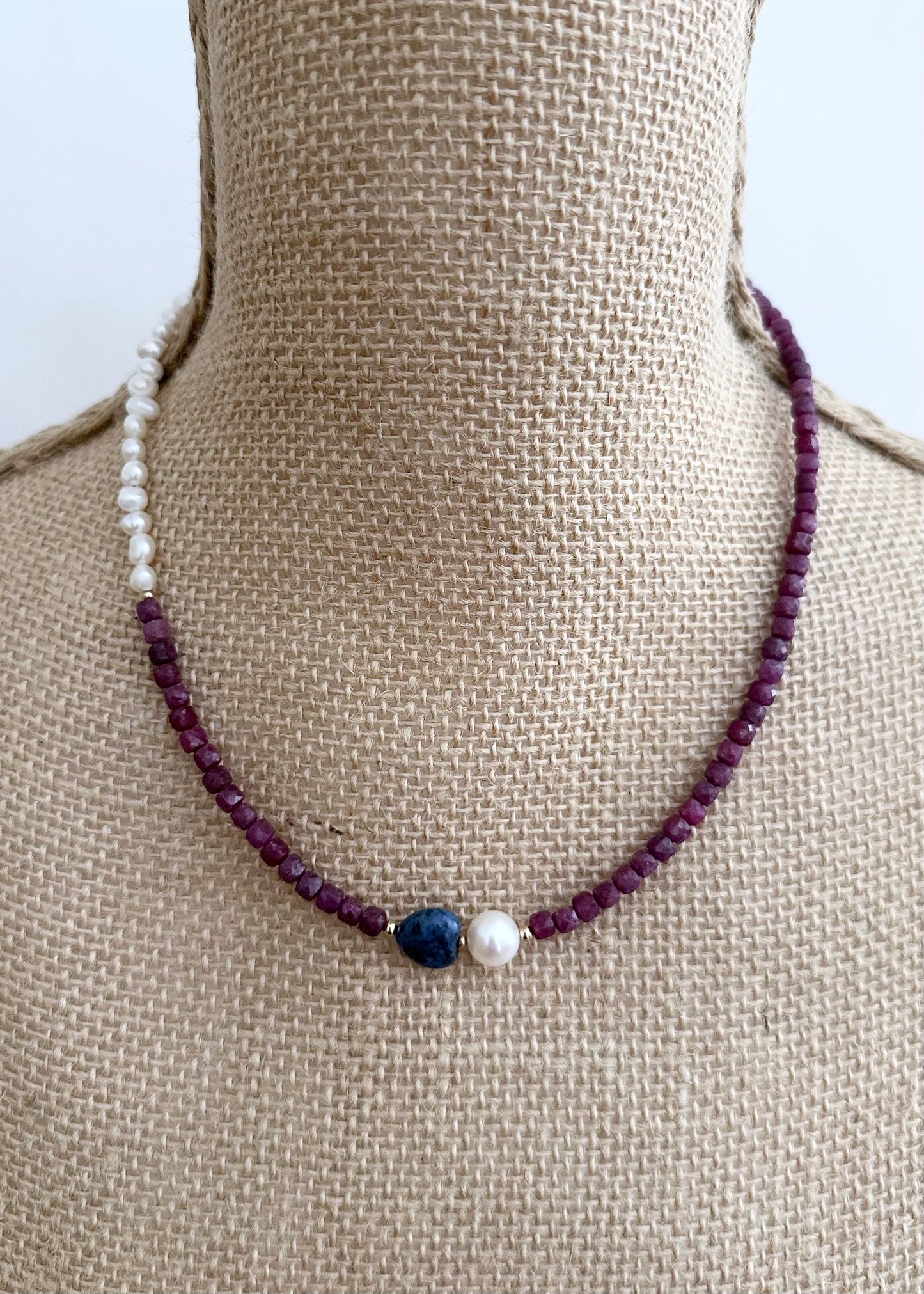 Designed and made in Canada, this Delicate One-Of-A-Kind 18” Necklace features Gorgeous Faceted 4mm Ruby, a Blue 10mm Dumortierite Heart and White Pearls accented with Gold Beads and finished with a Gold-Filled Hook Clasp.