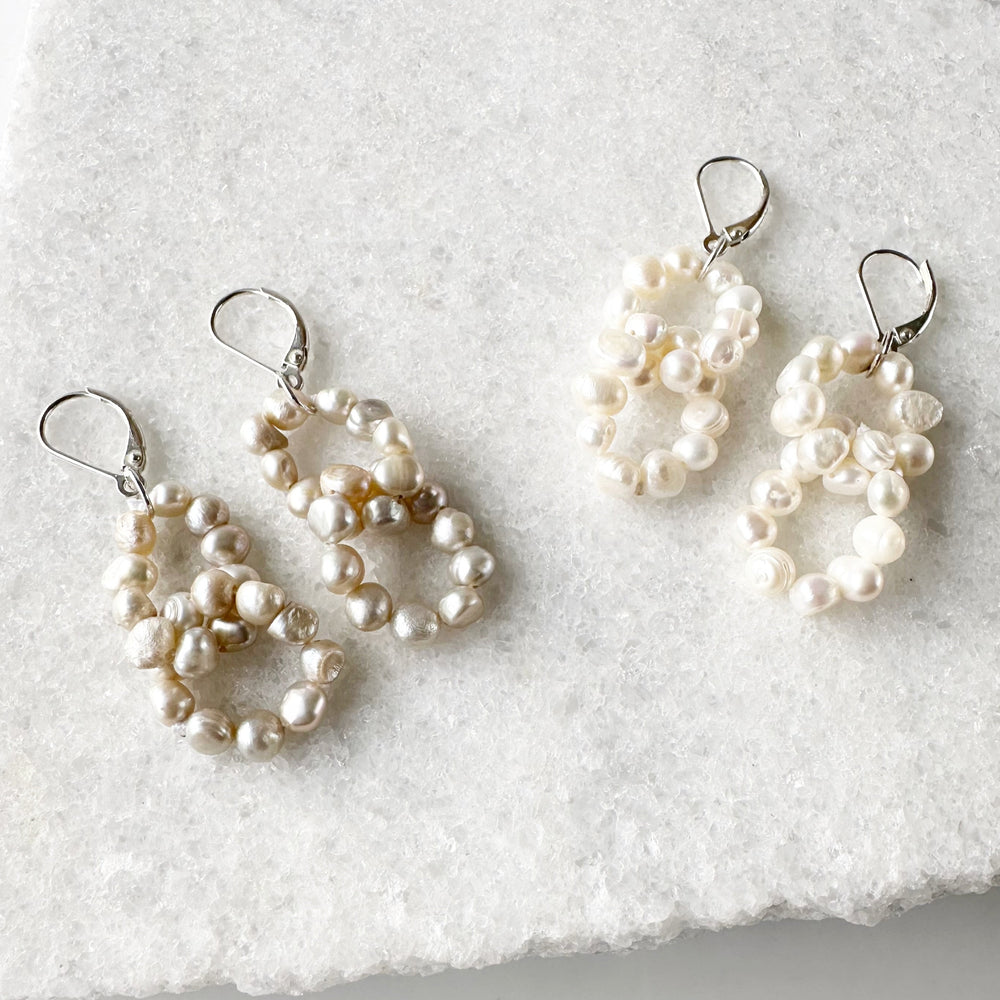 
                      
                        Two Linked Rings of Tiny White or Champagne Baroque Freshwater Pearls highlight these Earrings with Sterling Silver Lever Backs.
                      
                    