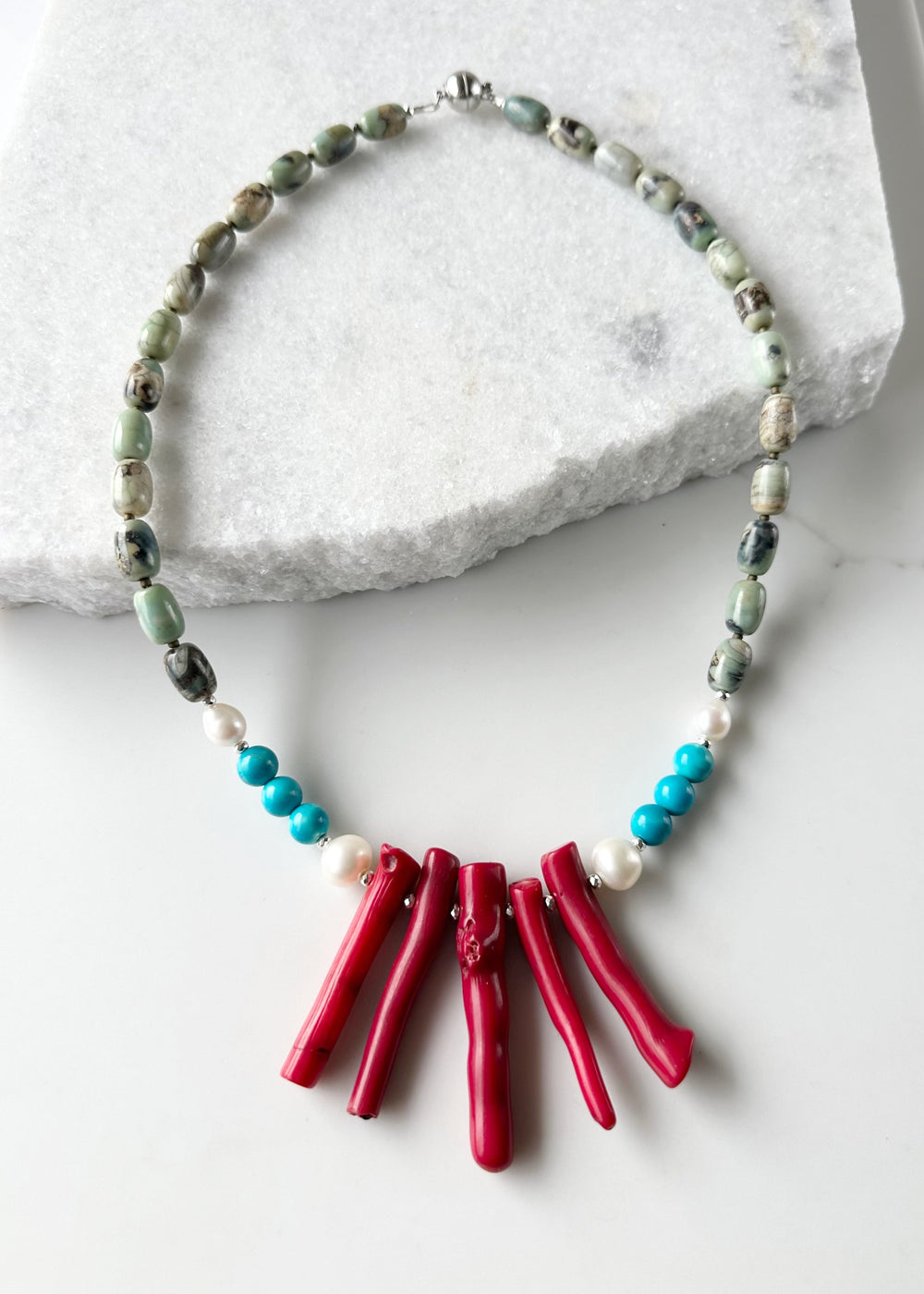 This 21” Statement Necklace Boasts Red Sea Bamboo, Terra Agate, Turquoise and Beautiful White Freshwater Pearls and are finished with Silver Beads and a Magnetic Ball Clasp for Easy Wear.