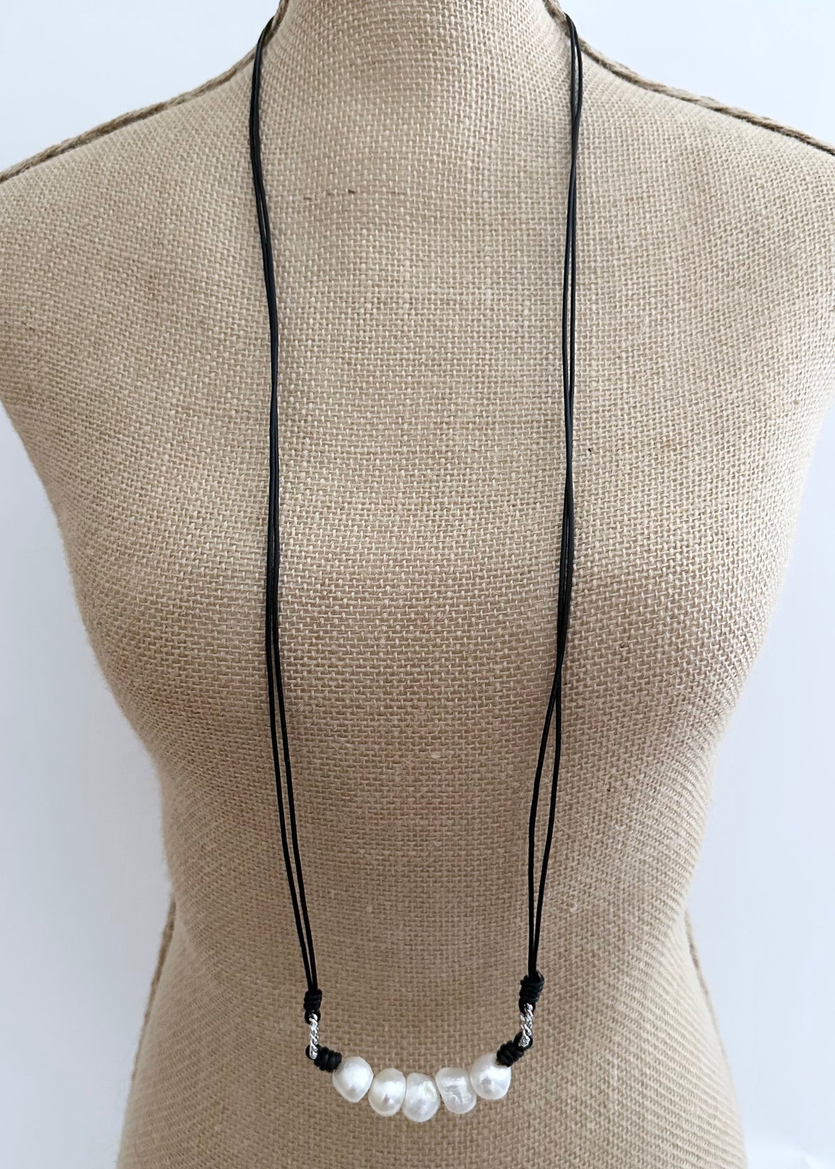 Designed in Canada, this 40” Long Necklace (Drop of 19”) Features 5 Large Freshwater Pearls Surrounded by White Gold-plated Rings on two Strands of Leather. It slips on for any easy, casual look and feel.