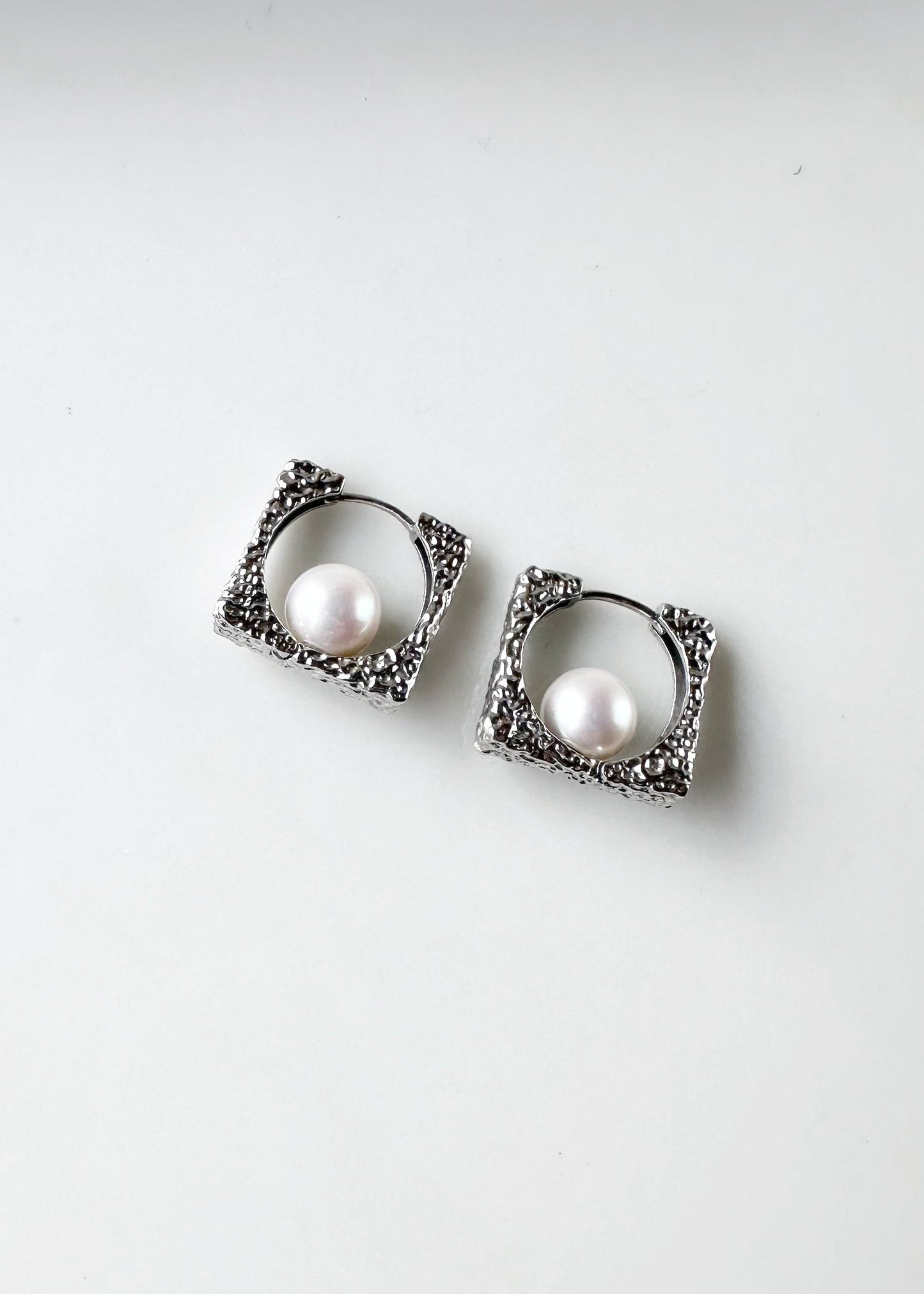 These Unique Earrings have Lustrous A+ White 8mm Freshwater Pearls Nestled in Hammered Silver Squares for a Modern Look. The Hinged Closure keeps everything Secure and Comfortable.  This piece is Completed with Sterling Silver Hammered Hoops.