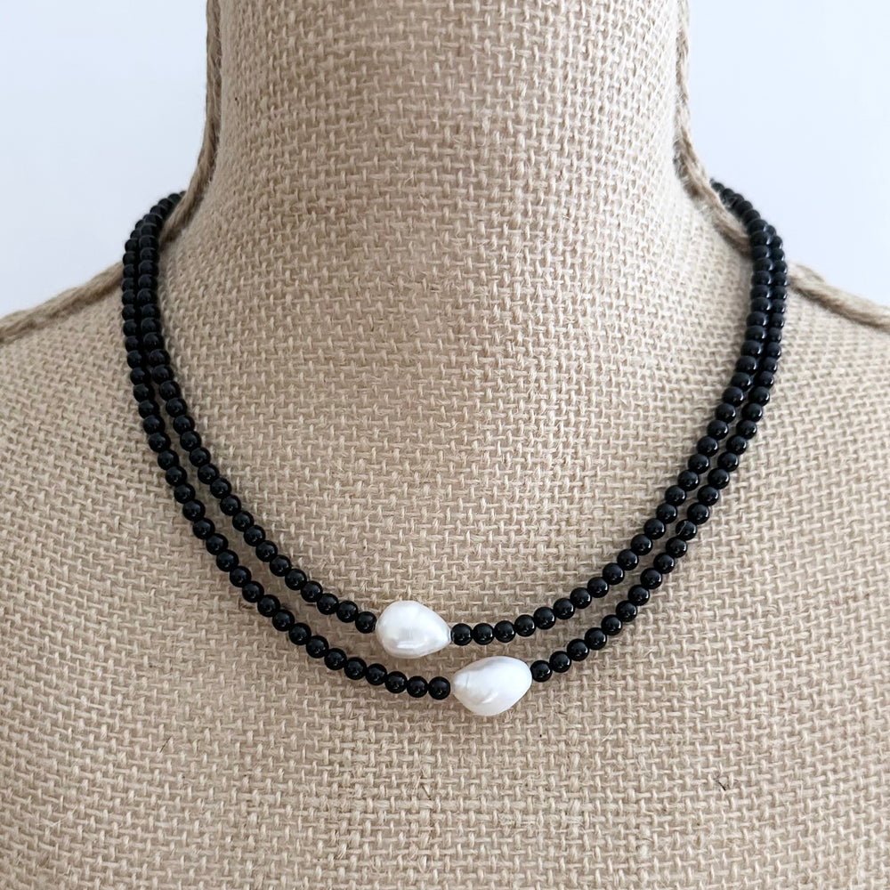 
                      
                        Two Lustrous White Baroque Freshwater Pearls are Highlighted and Offset on an 18” Necklace of Two Strands with 4mm Black Semi-Precious Stones Finished with a Strong Secure Magnetic Clasp for Easy Wear. On Bust
                      
                    