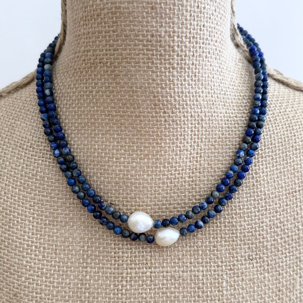 
                      
                        Two Lustrous White Baroque Freshwater Pearls are Highlighted and Offset on an 18” Necklace of Two Strands with 4mm Blue Semi-Precious Stones Finished with a Strong Secure Magnetic Clasp for Easy Wear. On Bust
                      
                    
