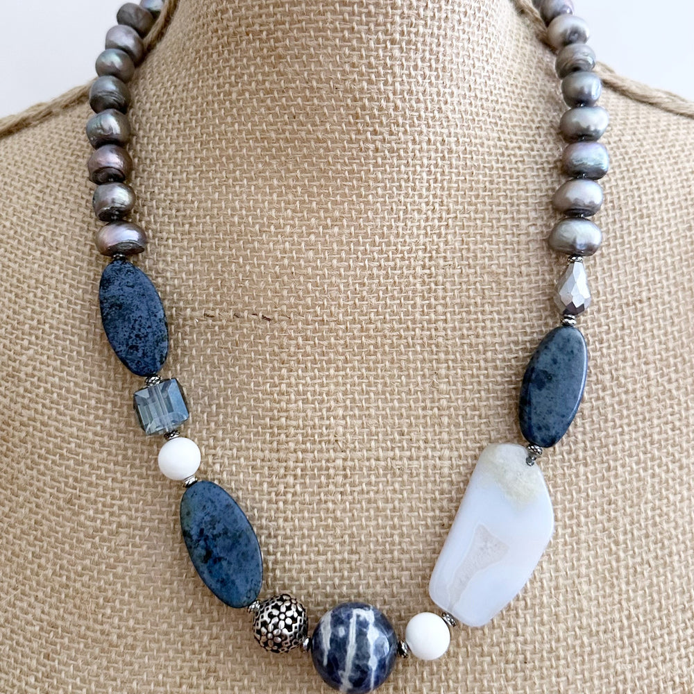 This Unique 23” Necklace Combines a Captivating Blend of Sodalite, Blue Lace Agate, Dumortierite, Silver, Crystal, Silver Freshwater Pearls and Finished with a Magnetic Clasp, Creating a Truly Distinctive Piece. Designed and made in Canada