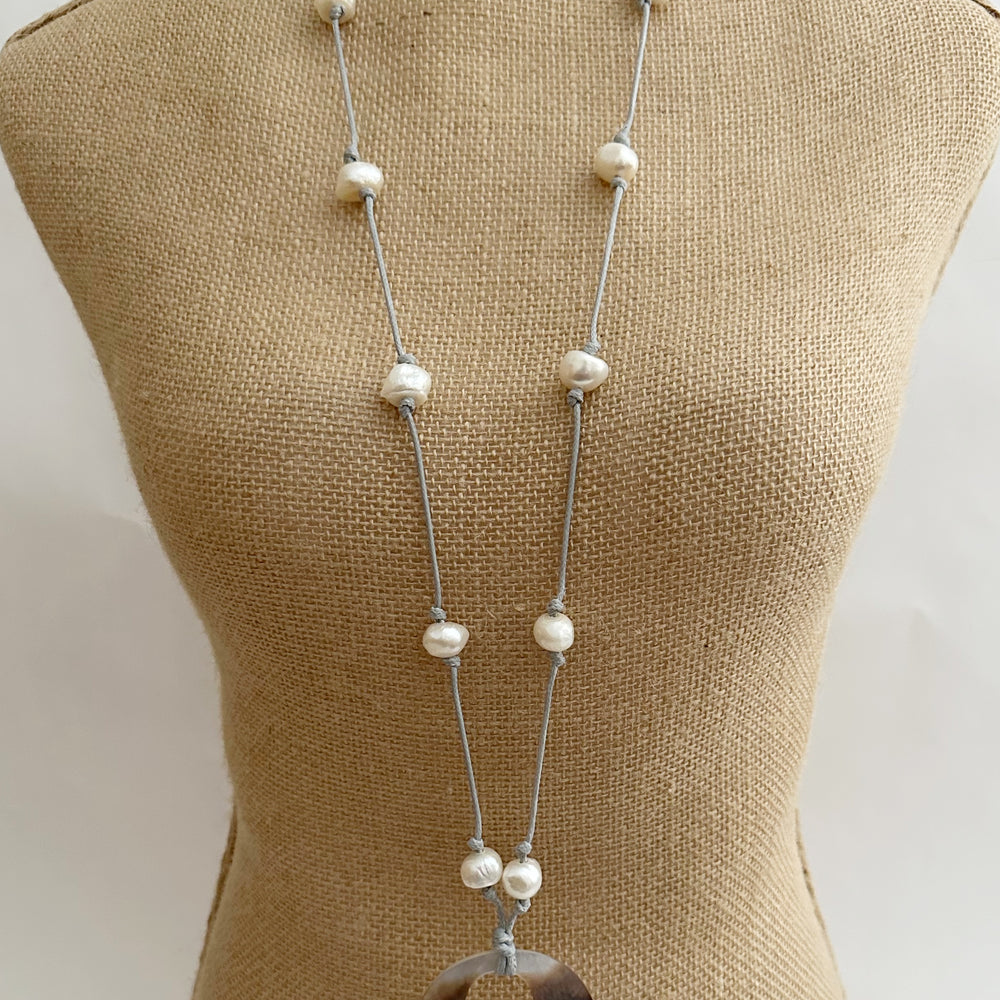 
                      
                        Lustrous White Baroque Freshwater Pearls are Knotted on White Waxed Cotton with Shell Pendant on this Lightweight 21” Necklace. On Bust
                      
                    
