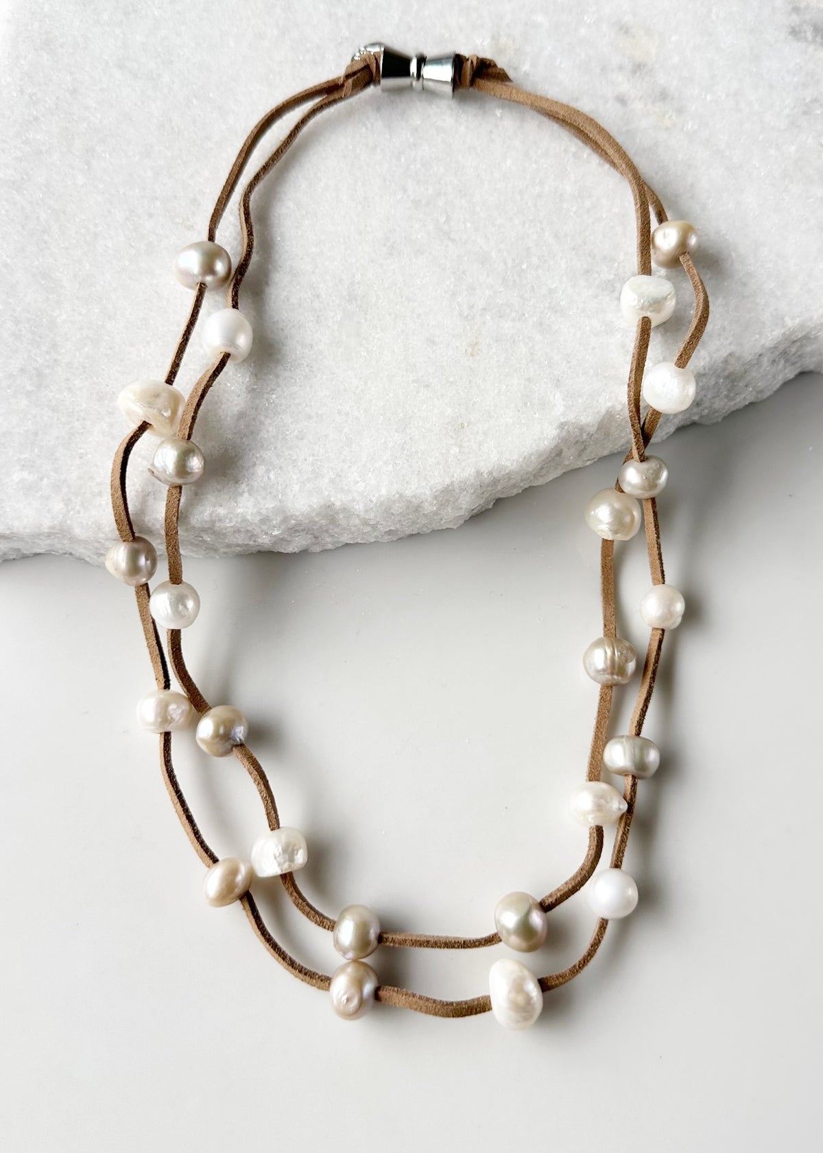 Designed in Canada, the 21.5” Suki Necklace has 2 strands of Large Organic Freshwater Pearls Floating on Vegan Suede (six Colour Options). It's Finished with a Magnetic Clasp for Easy Wear.