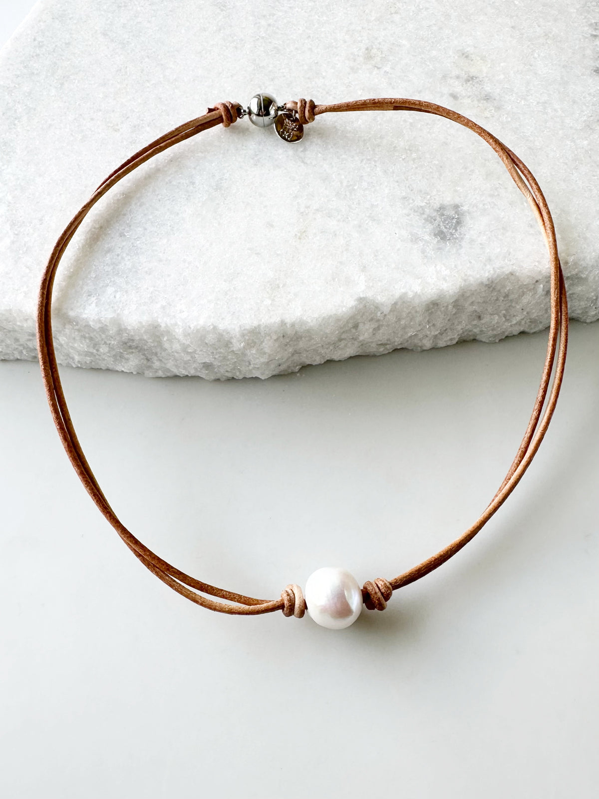 Designed in Canada, the 17” Tegan Necklace features One Large, Lustrous, Freshwater Pearl suspended on Two Strands of Leather and finished with a Magnetic Clasp for Easy Wear. Tegan is Pretty and Understated for an Elegant Style.