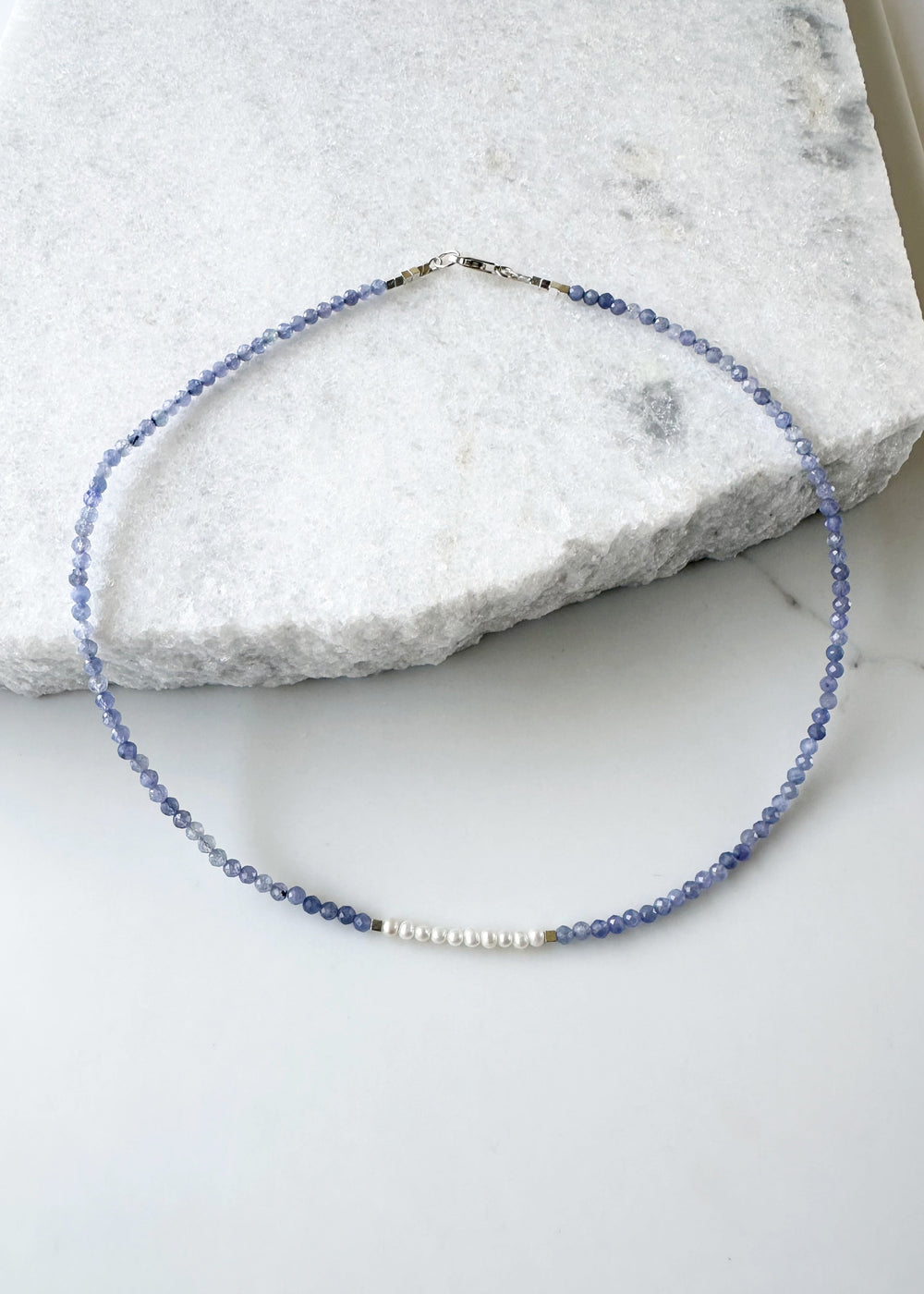Designed and made in Canada, this Charming, Limited Edition, 17.5” Necklace has Beautiful Blue Tanzanite and Tiny Lustrous White Pearls for a Delicate and pretty look.  It is finished with Hematite and a Sterling Silver Lobster Claw Clasp.