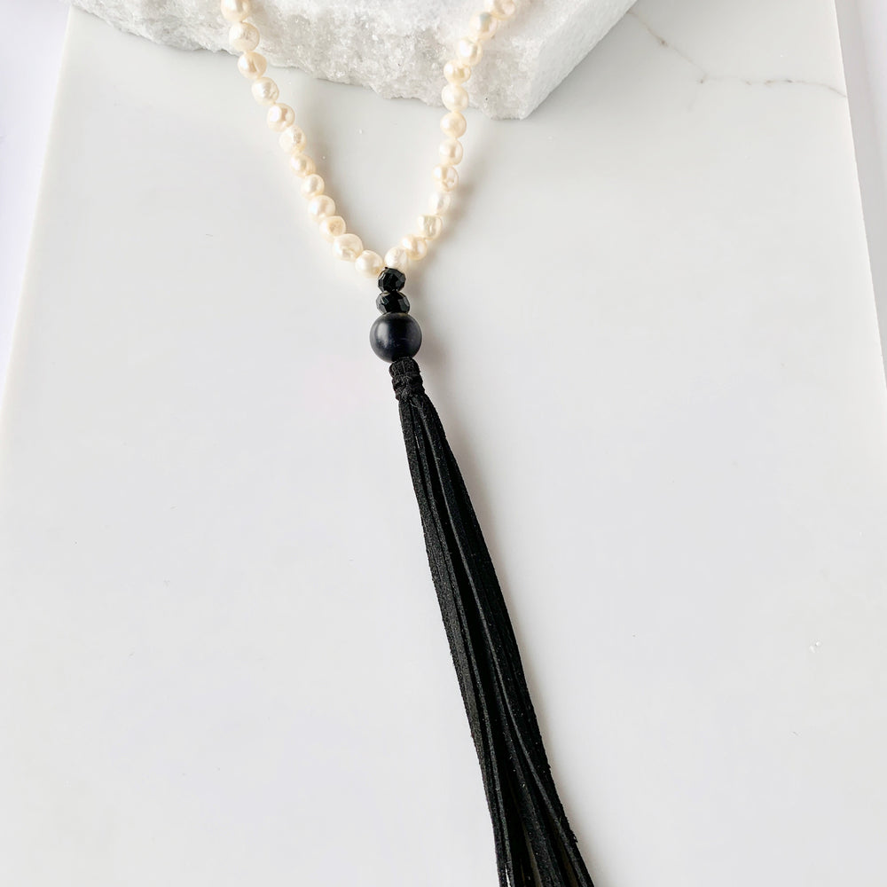 
                      
                        Freshwater Baroque White 8-9mm Pearls with Agate and Crystal and a Vegan Suede Tassel in Long 23” Necklace. Great on its own or Layered. Focus on Tassel
                      
                    