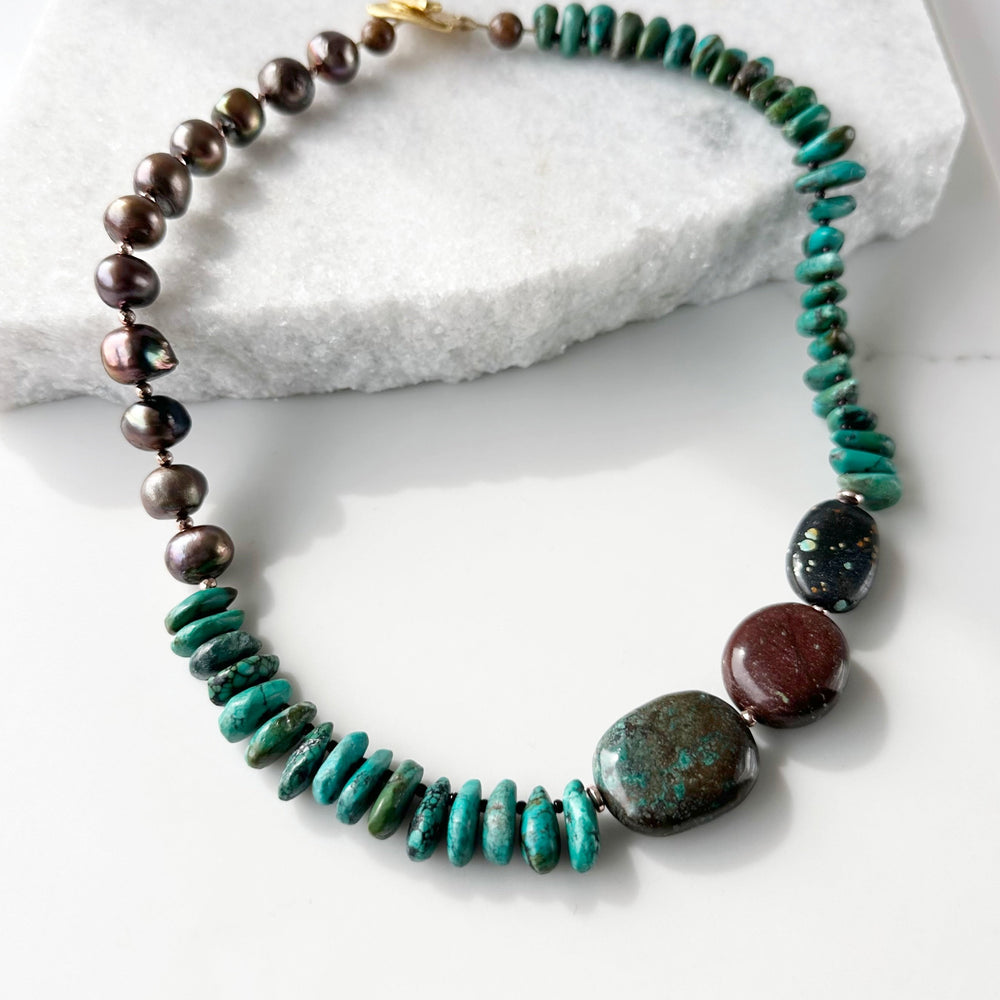 Rich Brown Baroque Freshwater Pearls, Brown and Blue Turquoise, Gold-Plated Hematite and Glass Beads are strung in Asymmetrical Fashion to form this One-Of-A-Kind 20” Necklace with Gold-Plated Toggle Clasp.