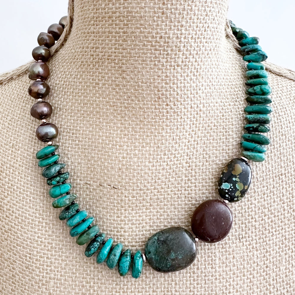 Rich Brown Baroque Freshwater Pearls, Brown and Blue Turquoise, Gold-Plated Hematite and Glass Beads are strung in Asymmetrical Fashion to form this One-Of-A-Kind 20” Necklace with Gold-Plated Toggle Clasp.
