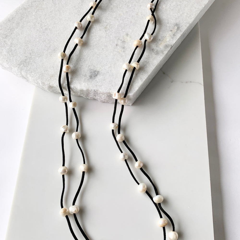 
                      
                        Large Baroque Freshwater White Pearls Floating on Two Strands of Black Vegan Suede for 40” Long Necklace Completed with Strong Secure Magnetic Clasp for Easy Wear.
                      
                    
