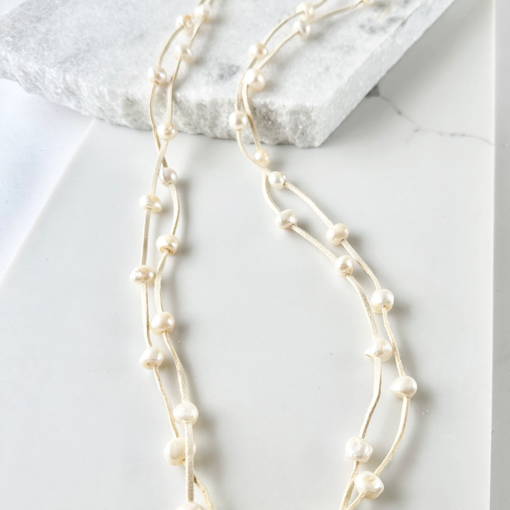 
                      
                        Large Baroque Freshwater White Pearls Floating on Two Strands of Cream Vegan Suede for 40” Long Necklace Completed with Strong Secure Magnetic Clasp for Easy Wear.
                      
                    