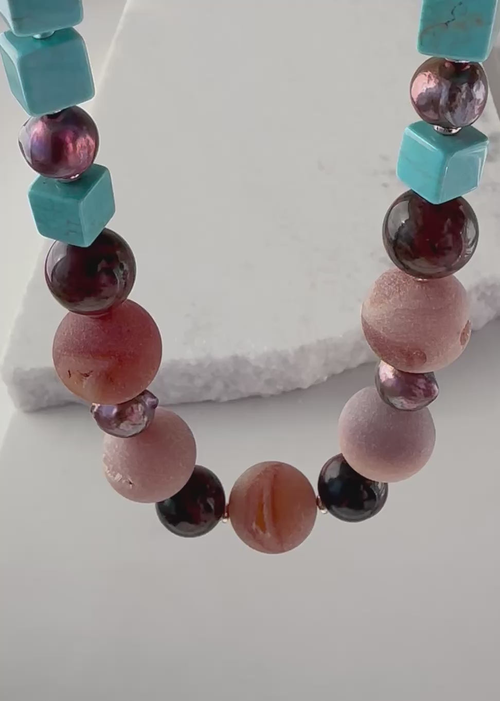 Designed and made in Canada, this One-Of-A-Kind 24” Necklace features Large Round Druzy Agate, Mahogany Obsidian, Turquoise Magnesite and Beautiful Brown Pearls. This piece is completed with Glass Seed Beads, Rose Gold-Plated Hematite and a Copper Toggle Clasp.