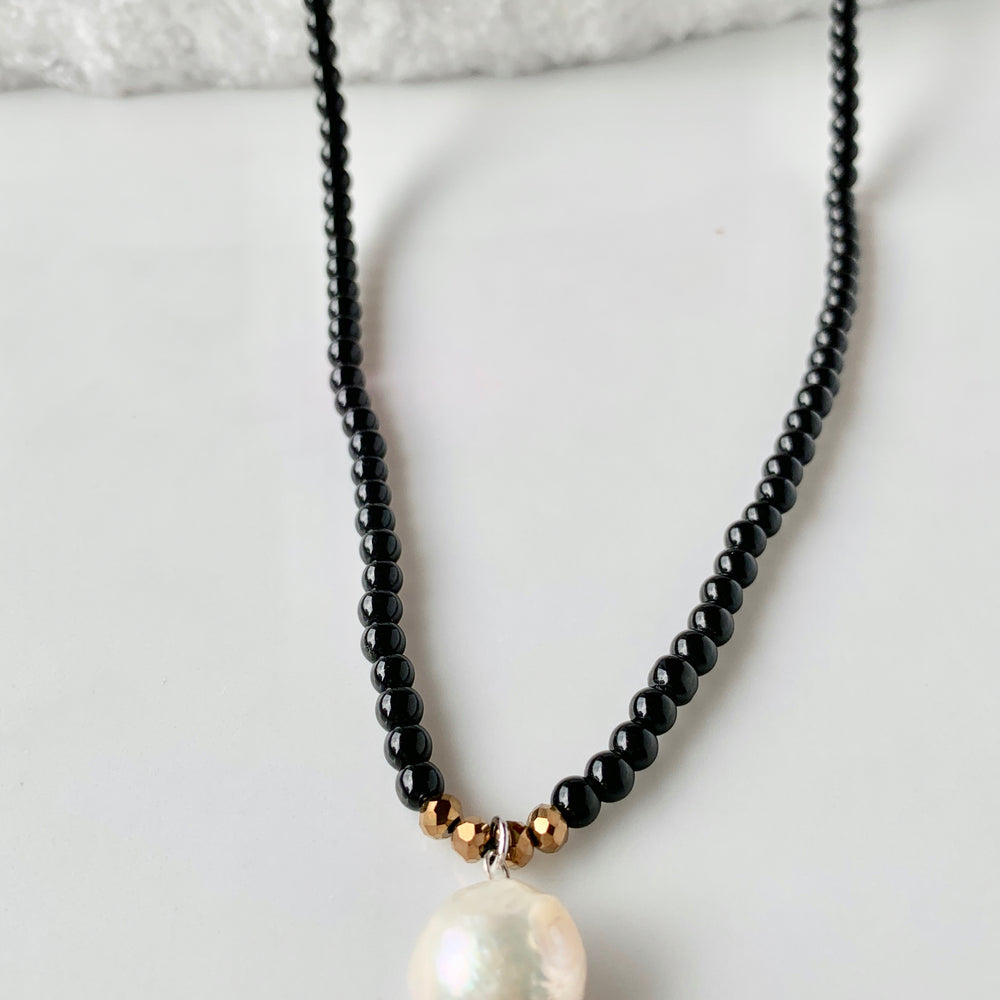 
                      
                        Simple and Elegant, a Large Freshwater Pearl Drop on this Black Agate Necklace with Gold Accents. Can be worn on its own or Stacked with other Necklaces. Drop in Focus
                      
                    