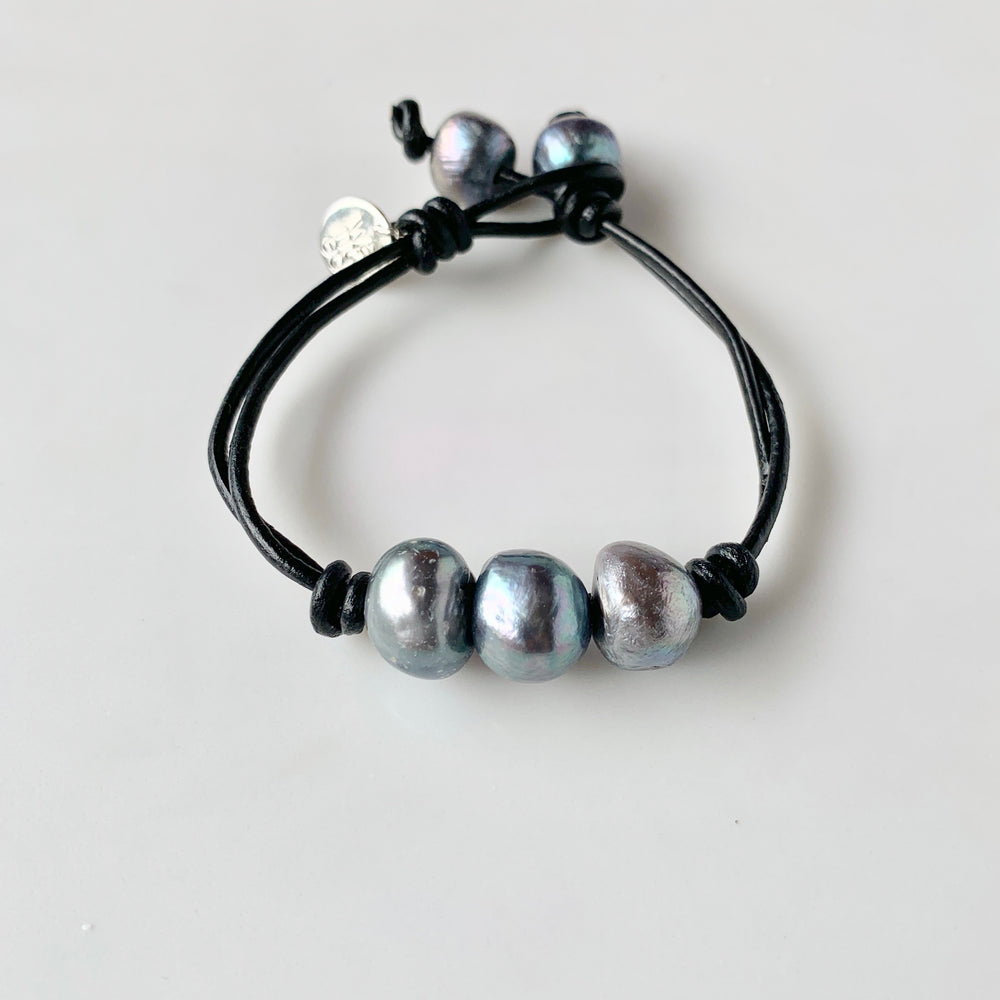
                      
                        Black Leather Bracelet Highlighting Three Black Baroque Freshwater Pearls with a Separate Pearl and Loop Closure. Can be worn Separately or Layered with other Bracelets.
                      
                    