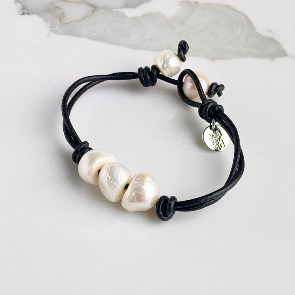 Black Leather Bracelet Highlighting Three White Baroque Freshwater Pearls with a Separate Pearl and Loop Closure. Can be worn Separately or Layered with other Bracelets.