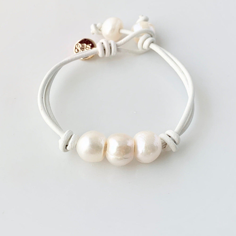 
                      
                        White Leather Bracelet Highlighting Three White Baroque Freshwater Pearls with a Separate Pearl and Loop Closure. Can be worn Separately or Layered with other Bracelets.
                      
                    