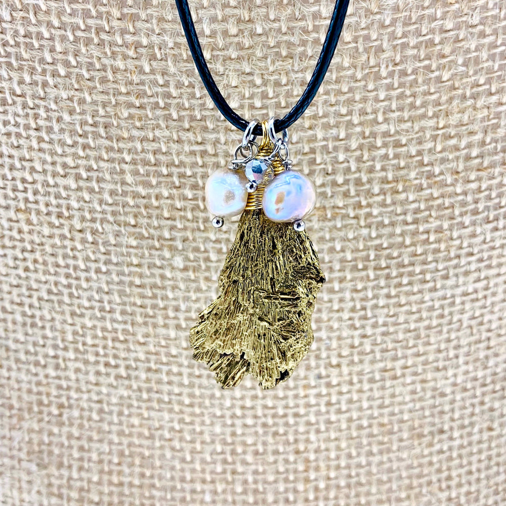 
                      
                        Champagne Baroque Freshwater Pearls and Faceted Crystals Dangling on Black Cotton Cord For a  Necklace with Plated Tourmaline Pendant giving a 23.6” Drop. Focus on Pendant
                      
                    