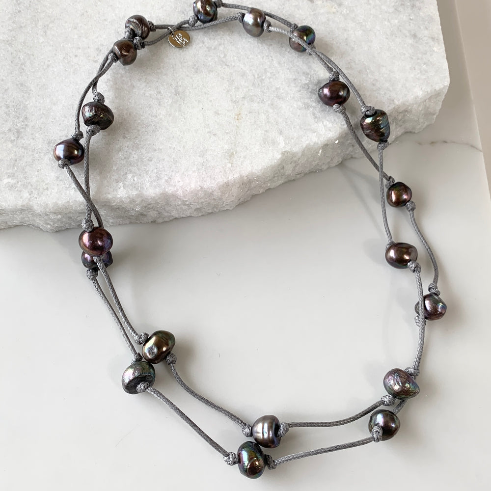
                      
                        Lustrous Black Freshwater Pearls Knotted on Grey Cotton in this 21” Necklace. Shown Doubled
                      
                    