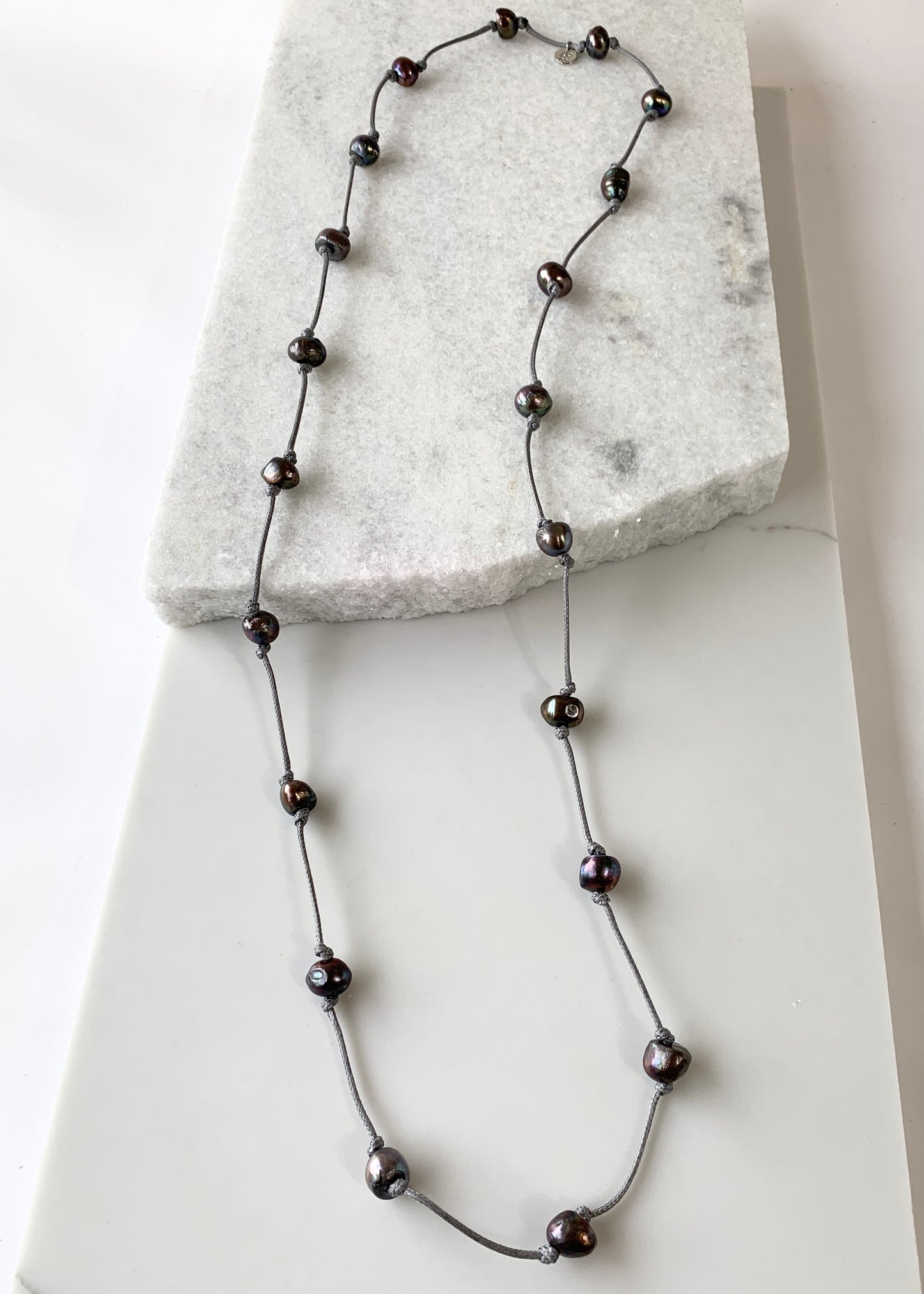 Lustrous Black Freshwater Pearls Knotted on Grey Cotton in this 21” Necklace.